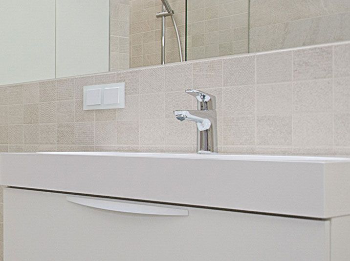 A white bathroom with a sink and a mirror.